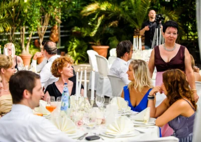 Gaste bei einer Hochzeit in Alte Gartnererei Taufkirchen geniessen ein festliches Abendessen im Freien.