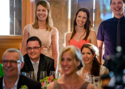 Gäste lachen bei einer Hochzeitsfeier im Gut Schloss Sulzemoos, festgehalten von einem Hochzeitsfotografen.