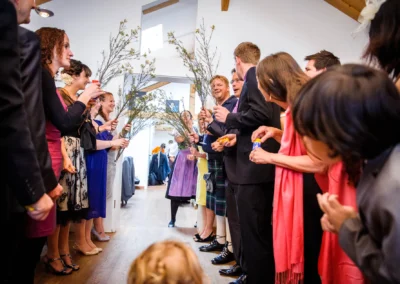 Hochzeitsfoto: Menschen bilden Spalier mit Zweigen bei Hochzeit im Bio Landhotel Moarwirt, Oberbayern.