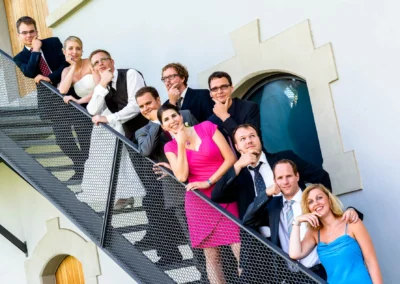 Hochzeitsfoto in Kloster Fuerstenfeld: Gruppe auf Treppe bei Feier in Oberbayern. Hochzeitsreportage nahe Muenchen.