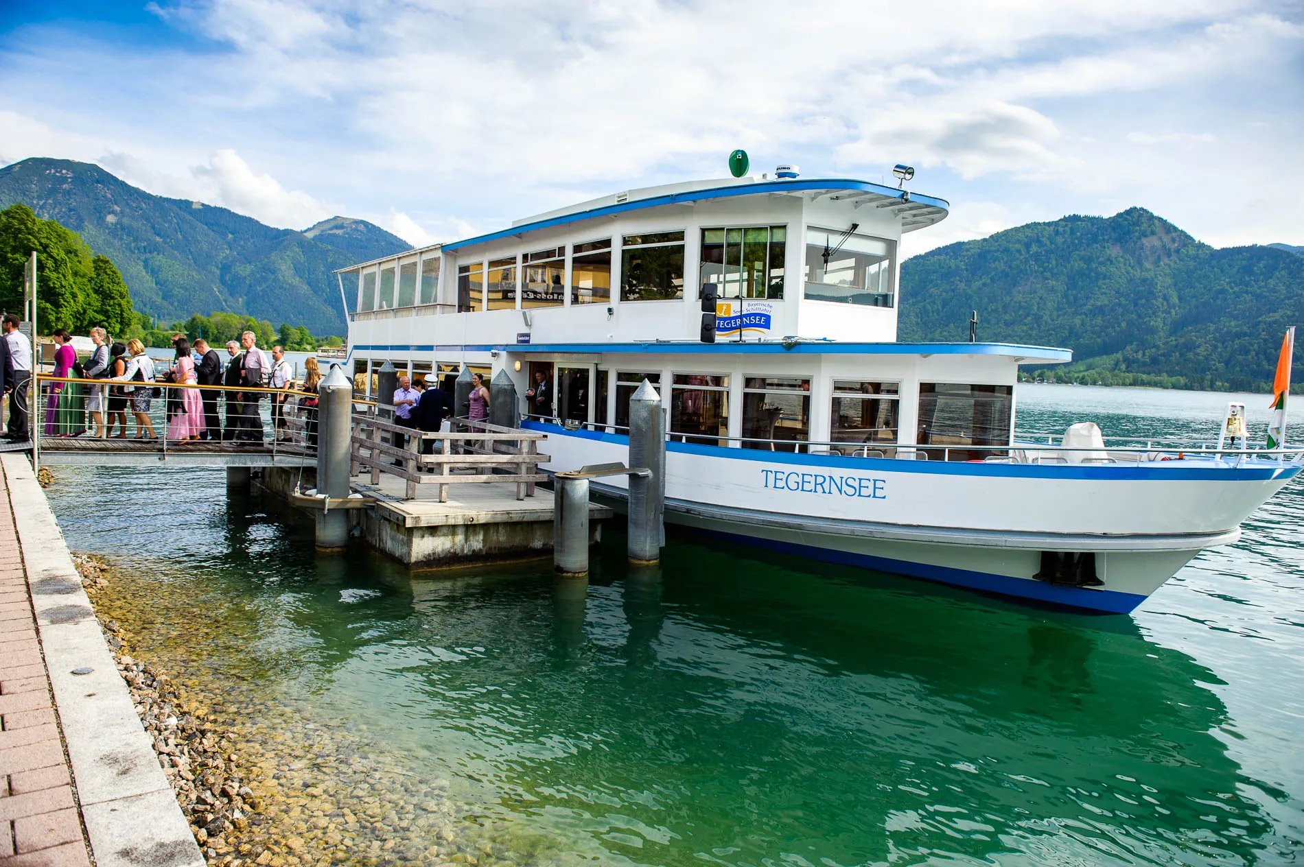 Hochzeitsgesellschaft auf einem Schiff am Tegernsee, Kulisse fuer Hochzeitsfotografie in Bayern.
