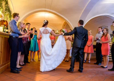 Brautpaar tanzt in einem Saal auf Gut Schloss Sulzemoos, umgeben von Gästen bei der Hochzeitsfeier.