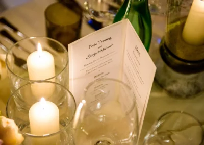 Kerzen und Speisekarte auf Hochzeitstafel in Gasthof Stangl. Hochzeitsreportage in Neufarn bei Muenchen.