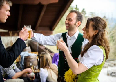 Gaste prosten sich mit Bier zu bei einer Hochzeit in Oberbayern. Hochzeitsfoto aufgenommen im Moarwirt Hechenberg.