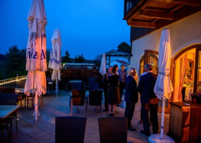Hochzeitsgesellschaft bei Nacht auf einer Terrasse in Grosshartpenning, Oberbayern. Hochzeitsfotografie im Freien.