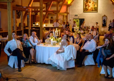Hochzeitsgesellschaft in festlichem Saal auf Gut Georgenberg, Blick auf Brautpaar bei Hochzeitsreportage.