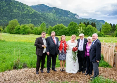 Hochzeitsfoto mit Braut und Gästen in Kreuth, umgeben von malerischer Berglandschaft in Oberbayern.