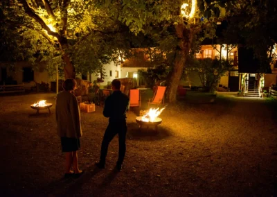 Nachtaufnahme einer Hochzeit bei Feuerschalen auf Gut Georgenberg, stimmungsvolle Hochzeitsreportage in Oberbayern.