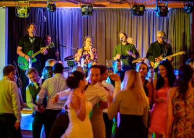 Hochzeitsfoto im Gasthof Widmann: Gäste tanzen zur Livemusik bei einer Hochzeit. Stimmungsvoll und lebendig.