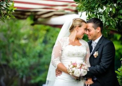 Brautpaar umarmt sich bei Hochzeitsportrait in der Alten Gaertnerei Taufkirchen, Hochzeitsfotografie in romantischer Kulisse.