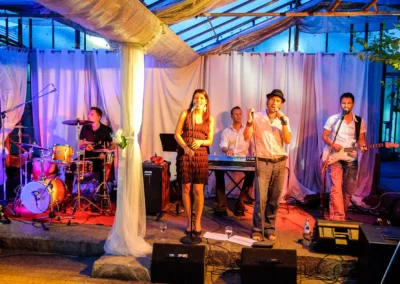 Band spielt bei einer Hochzeit in Taufkirchen bei Muenchen, beleuchtet von bunten Lichtern. Hochzeitsfotografie.