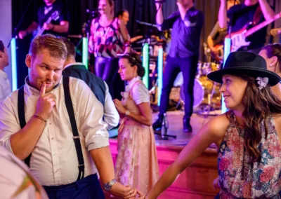 Tanzendes Paar bei einer Hochzeit in Gasthof Widmann, Gilching. Fröhliche Hochzeitsreportage mit Band im Hintergrund.