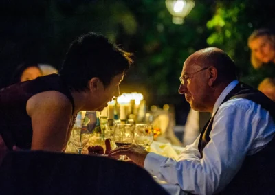 Gespraech zweier Gaeste bei einer Hochzeit in Taufkirchen bei Kerzenschein, aufgenommen vom Hochzeitsfotografen.