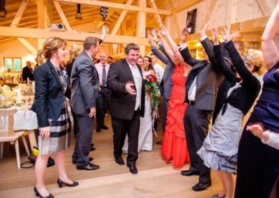 Hochzeitsgesellschaft feiert bei einer Hochzeitsreportage in der Naturkaeserei Tegernseer Land.