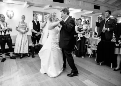 Brautpaar tanzt bei Hochzeit in Kreuth, umgeben von Gästen in traditioneller Kleidung. Hochzeitsfotografie Momentaufnahme.