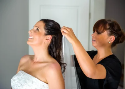Braut wird in Aufkirchen am Starnberger See von einer Frau beim Getting Ready mit dem Schleier geholfen. Hochzeitsreportage.
