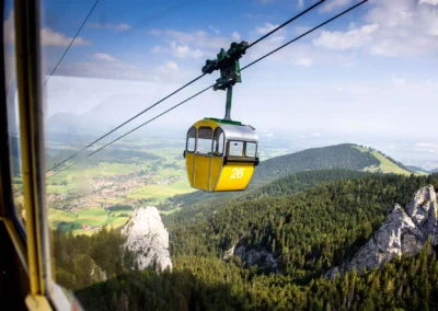 Kampenwand-Seilbahn ueber Wald und Berge nahe der Kampenwand, ideal fuer Hochzeitsfotos von Hochzeitsreportagen in Oberbayern.
