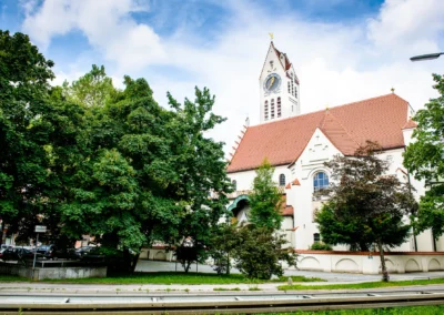 Erlöserkirche in München Schwabing umgeben von Bäumen, ideal für Hochzeitsfotos bei Ihrer Hochzeit.