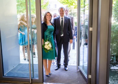 Brautpaar betritt das Standesamt Pasing, Hochzeitstrauung in Muenchen, elegante Hochzeitsfotografie.