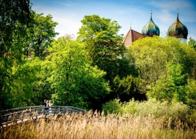 Brautpaar auf Holzbruecke im Gruen nahe Kloster Seeon im Chiemgau, Hochzeitsfotografie in Oberbayern nahe des Chiemsees.