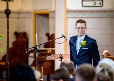 Bräutigam am Mikrofon in der Kirche bei der Trauung, Hochzeitsfotografie in der evangelischen Friedenskirche.