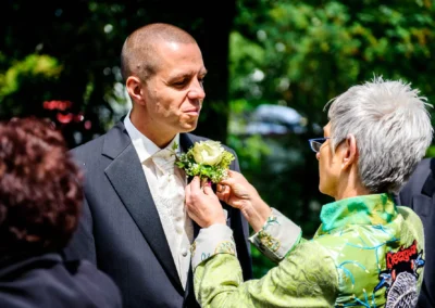 Bräutigam erhält Ansteckblume für kirchliche Trauung in Murnau; Hochzeitsfotograf aus Bayern dokumentiert.