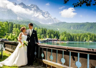 Brautpaar am Eibsee nahe Garmisch, Hochzeit bei sonnigem Wetter mit Bergkulisse und See im Hintergrund.