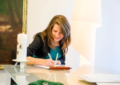 Frau unterschreibt Dokumente bei der standesamtlichen Trauung in Pasing, Hochzeitsfotografie in Muenchen.