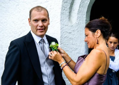 Bräutigam bekommt Blume am Anzug befestigt, Hochzeit auf Gut Thurnsberg Kranzberg, Hochzeitsfotografie.