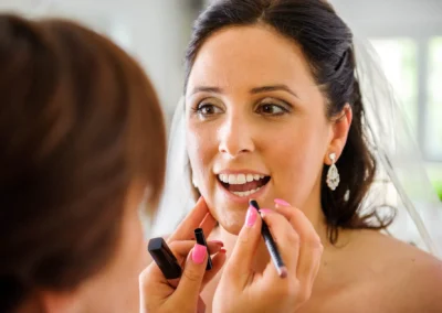 Braut beim Lippen Makeup in Aufkirchen vor der Hochzeit. Hochzeitsfotografie in Oberbayern.