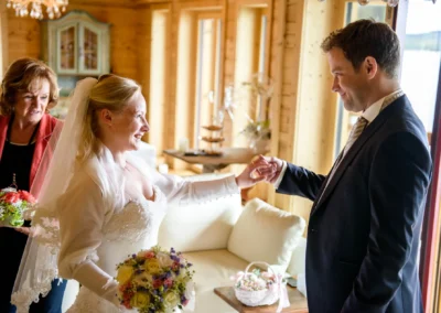 Braut beim Trauzeugen, Hochzeit am Tegernsee, festlicher Moment. Hochzeitsfoto in rustikaler Umgebung.