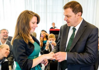 Standesamtliche Trauung in Muenchen. Brautpaar tauscht Ringe währende der Hochzeitsreportage im Standesamt Pasing.