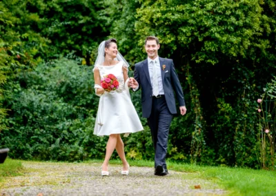 Brautpaar beim Spaziergang im Garten des Hotel Kaiserin Elisabeth am Starnberger See, Hochzeitsfotografie.