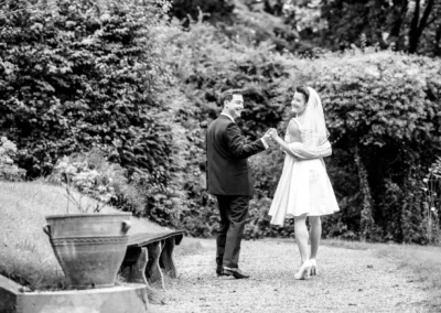 Brautpaar tanzt auf Gartenweg, Hochzeitsportrait in Feldafing, Hochzeitsfotografie im Freien.