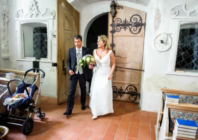 Hochzeitspaar betritt Kirche in Gmund am Tegernsee, aufgenommen bei einer Hochzeitsfotografie-Reportage.
