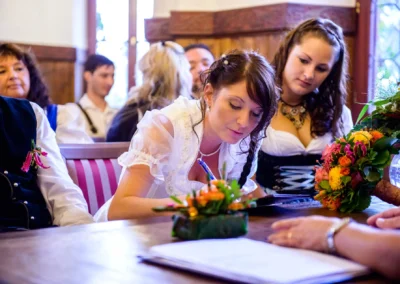 Braut unterschreibt Dokument bei standesamtlicher Trauung im Standesamt Herrsching, Hochzeitsfotografie.