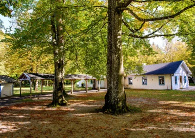 Waldhaus bei einer Hochzeit im Gruenwalder Forst mit Baeumen und Gebaeude im Hintergrund. Hochzeitsfotografie.