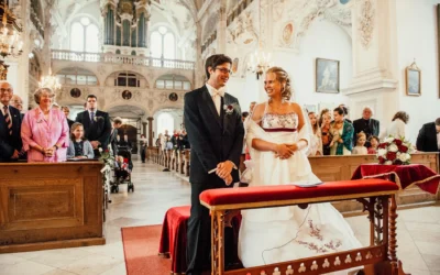 Brautpaar in Kirche bei Hochzeit nahe Bad Toelz, Hochzeitsfotografie mit Gästen während kirchlicher Trauung.