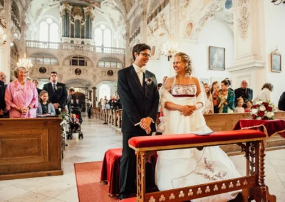 Brautpaar in Kirche bei Hochzeit nahe Bad Toelz, Hochzeitsfotografie mit Gästen während kirchlicher Trauung.