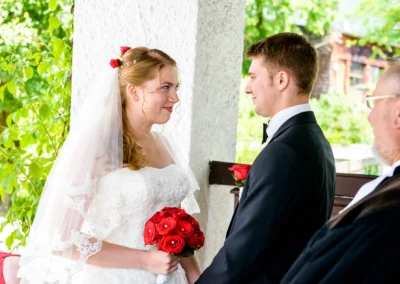 Brautpaar bei kirchlicher Trauung mit rotem Blumenstrauss in Garmisch, Teil einer Hochzeitsreportage in Oberbayern.