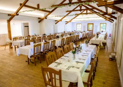Hochzeitslocation mit gedeckten Tischen und Holzdecke bei Hochzeit im Waldhaus Alte Tram Strasslach.