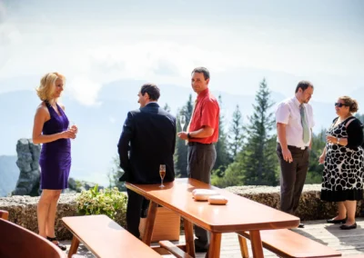 Gaste bei einer Hochzeit im Freien bei Aschau im Chiemgau, entspannte Atmosphare mit Bergen im Hintergrund.