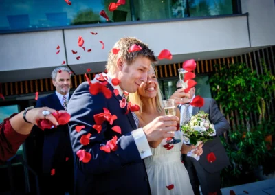 Brautpaar bei standesamtlicher Trauung, angestossen mit Sekt und Rosenblaettern in Bernried am See. Hochzeitsreportage.