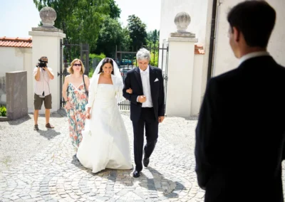 Braut mit Begleiter vor Kirche in Aufkirchen am Starnberger See, Hochzeitsfoto bei kirchlicher Trauung.