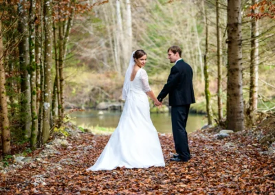 Brautpaar bei einer Hochzeit in Mangfall, posierend im Wald und Hand in Hand. Hochzeitsfoto Umgebung Natur.
