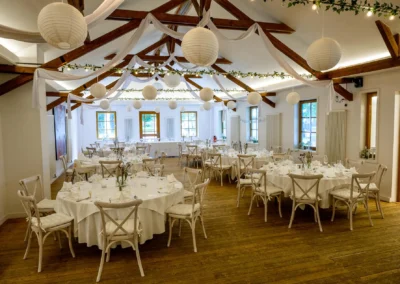Elegante Hochzeitslocation im Waldhaus Alte Tram bei Strasslach mit festlich dekorierten Tischen und weissen Lampions.