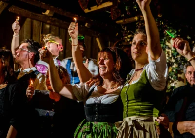 Gäste mit Feuerzeugen feiern auf einer Hochzeit zwischen München und Rosenheim. Hochzeitsreportage Fotograf.
