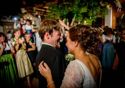 Brautpaar beim Tanz, umgeben von jubelnden Gaesten in Tracht bei einer Hochzeitsreportage in Kreis Rosenheim.