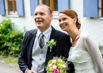 Brautpaar laechelt bei kirchlicher Trauung, aufgenommen von Hochzeitsfotograf bei Freising.