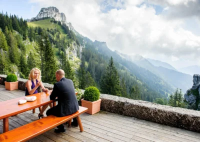 Paar bei der Hochzeit auf der Sonnenalm Kampenwand, genießt die Aussicht auf die Alpen. Hochzeitsreportage im Chiemgau.
